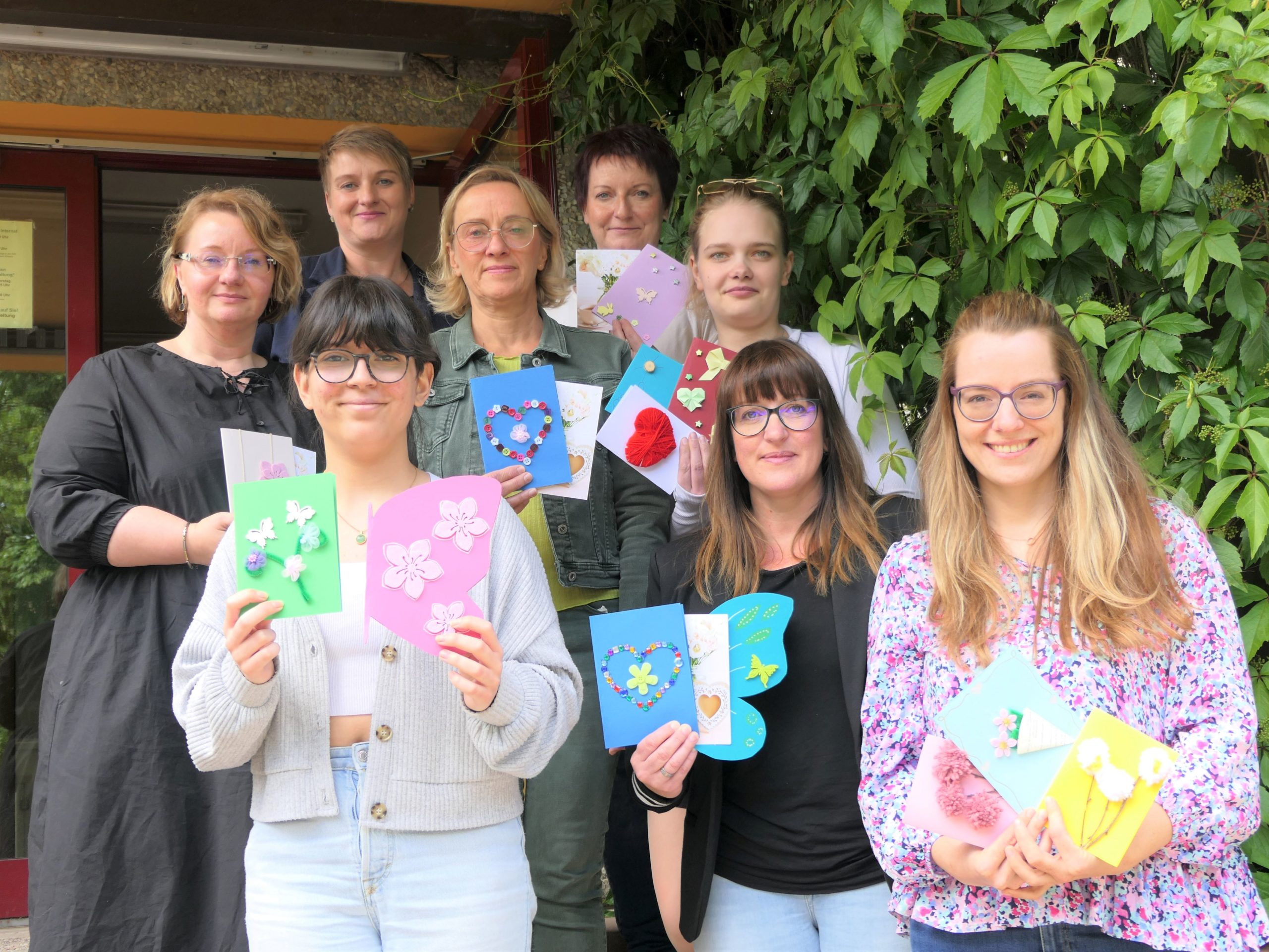 Bild: Stadt Gera / Die Schülerinnen Mariola Nonichef und Chantal May überreichen die selbst gestalteten 18 Postkarten an AGATHE Gera. 1. Reihe: Mariola Luzyna Amira Nouichef (Schülerin), Ines Borowsky und Steffi Hardell-Illgen (beide AGATHE), 2. Reihe: Sandra Maschke, Marion Opelt (beide Internat Gera), Chantal May (Schülerin), 3. Reihe: Monique Heinze (Leiterin Amt für Gesundheit und Versorgung), Dorit Hempel (Internat)